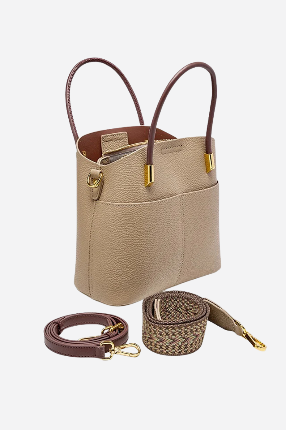 Beige handbag with brown handles and strap on a white background